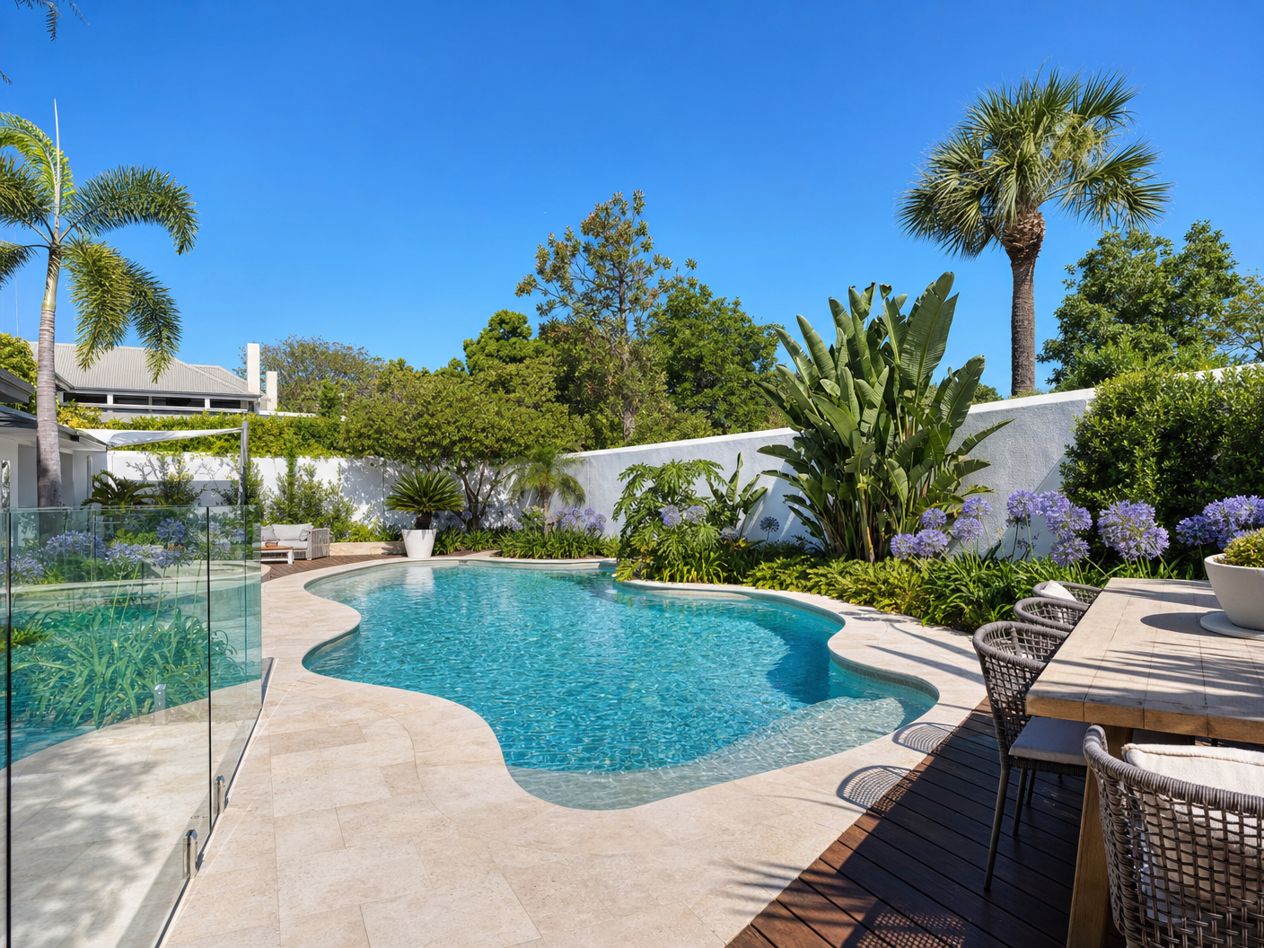 Freeform pool and tropical garden design in Claremont Perth with glass fencing and limestone pavers